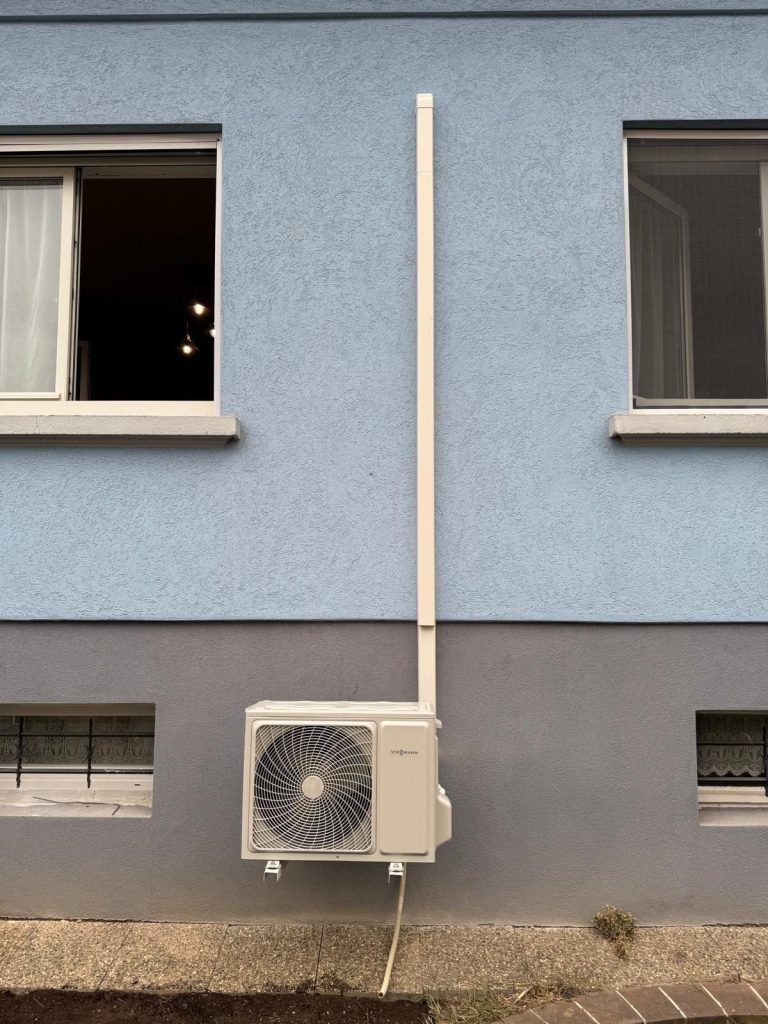 Unité extérieure de climatisation avec goulotte le long de la façade