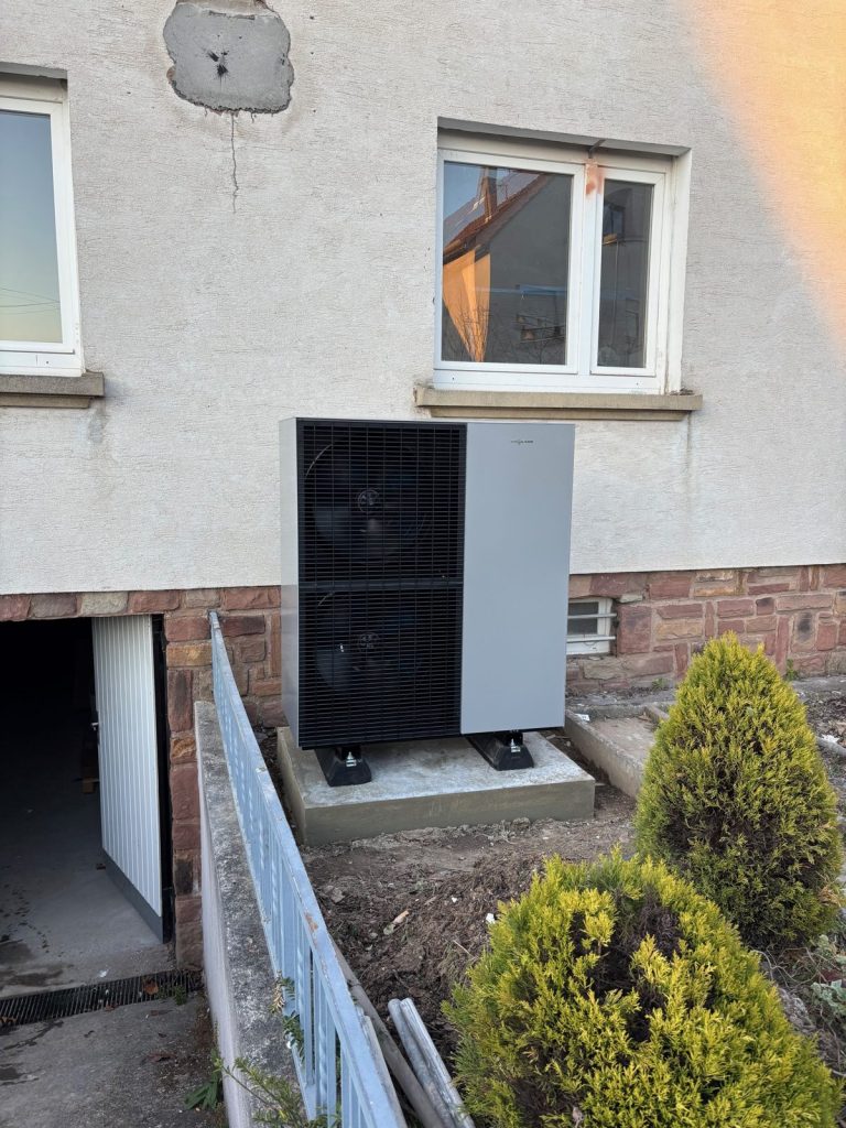 Unité extérieure de pompe à chaleur air/eau installée contre une maison